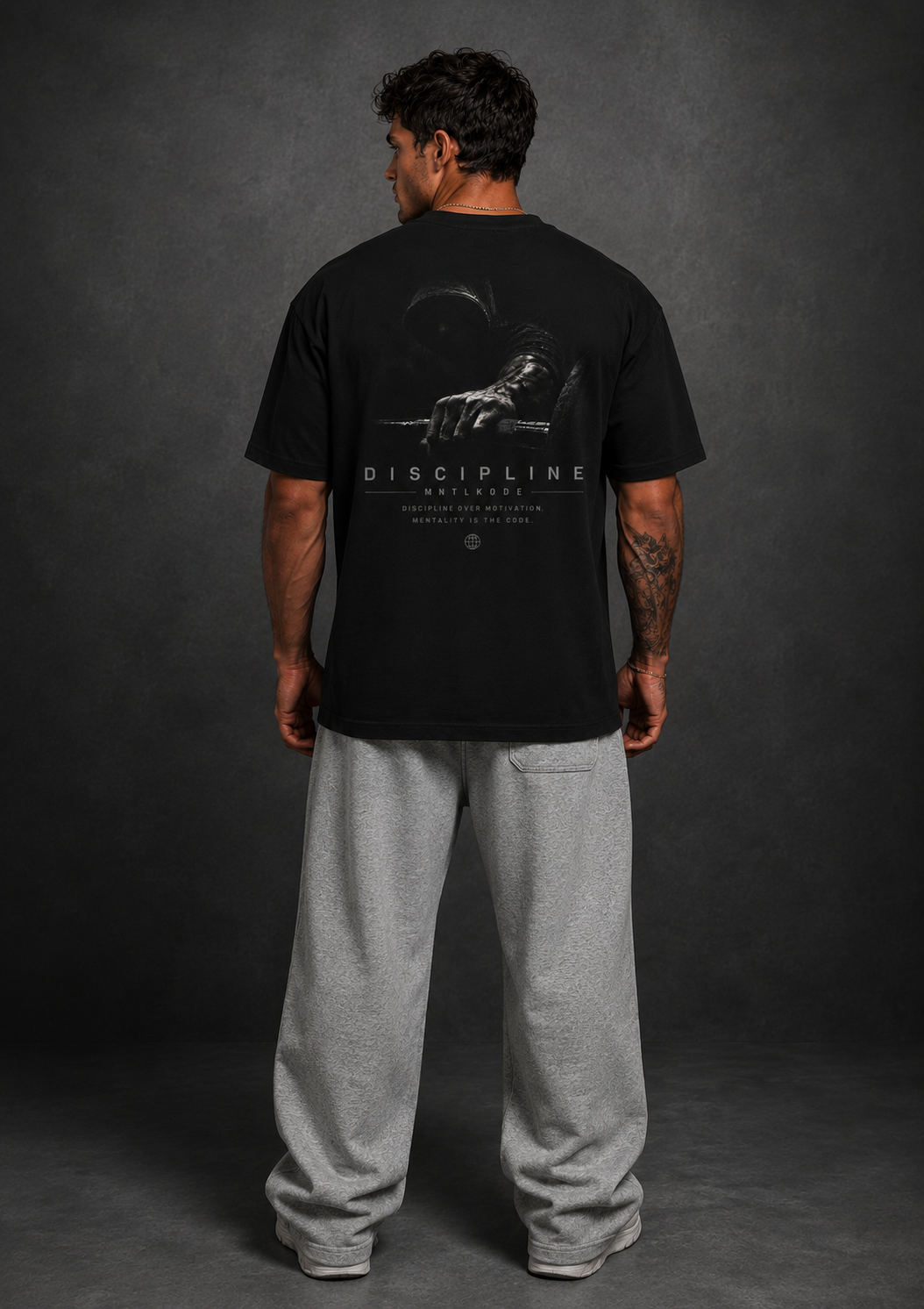 man wearing a black t-shirt with a graphic design on the back against a gray background